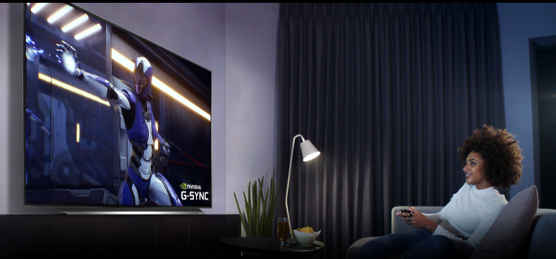 Gamer relaxing on couch while playing on large-screen TV